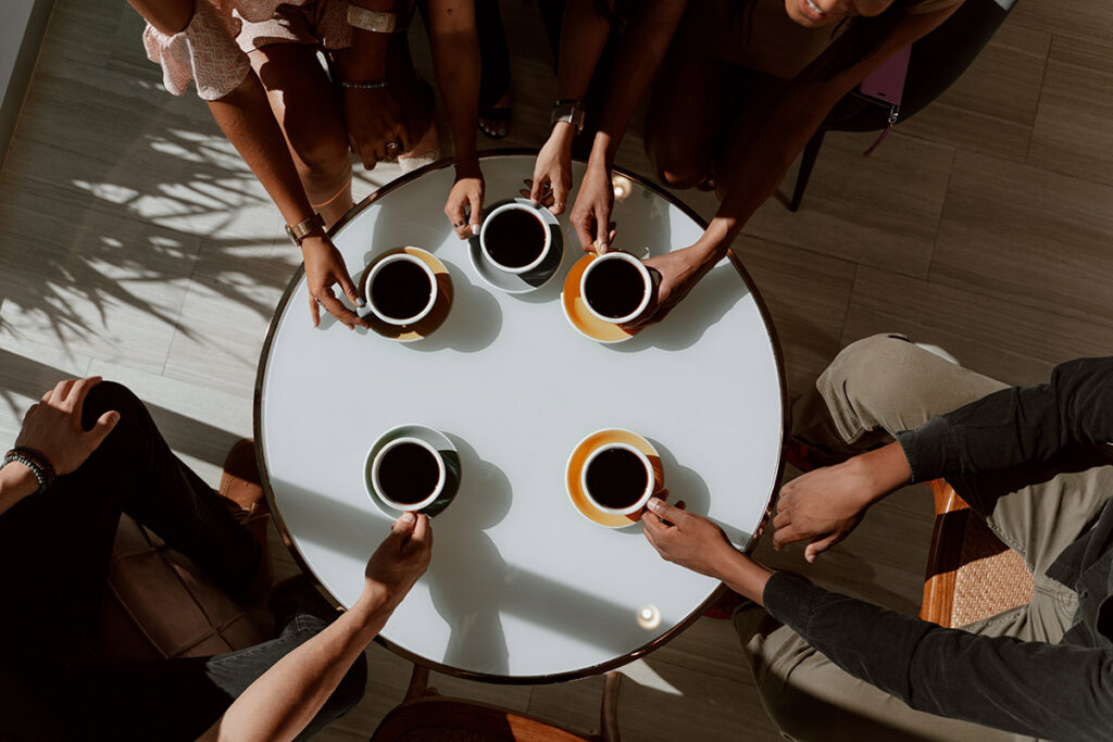 Group of friends drinking coffee around table