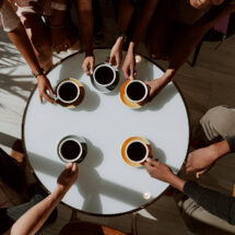 Group of friends drinking coffee around table